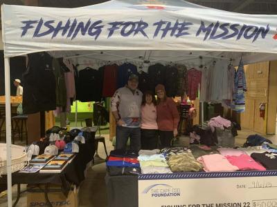 Volunteers stand at the Fishing for the Mission tent.